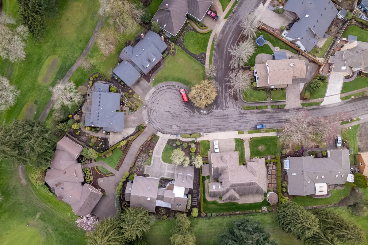 A tranquil cul-de-sac bordered by landscaped gardens, homes with varied architecture, and driveways. The peaceful street scene is perfect for scenic walks, providing safe, pleasant routes for pet owners.