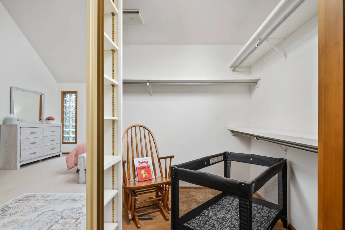 A cozy interior with a classic rocking chair, playpen, and a mirror. The environment is warm and inviting, making it ideal for quiet reading sessions or playtime with little ones.
