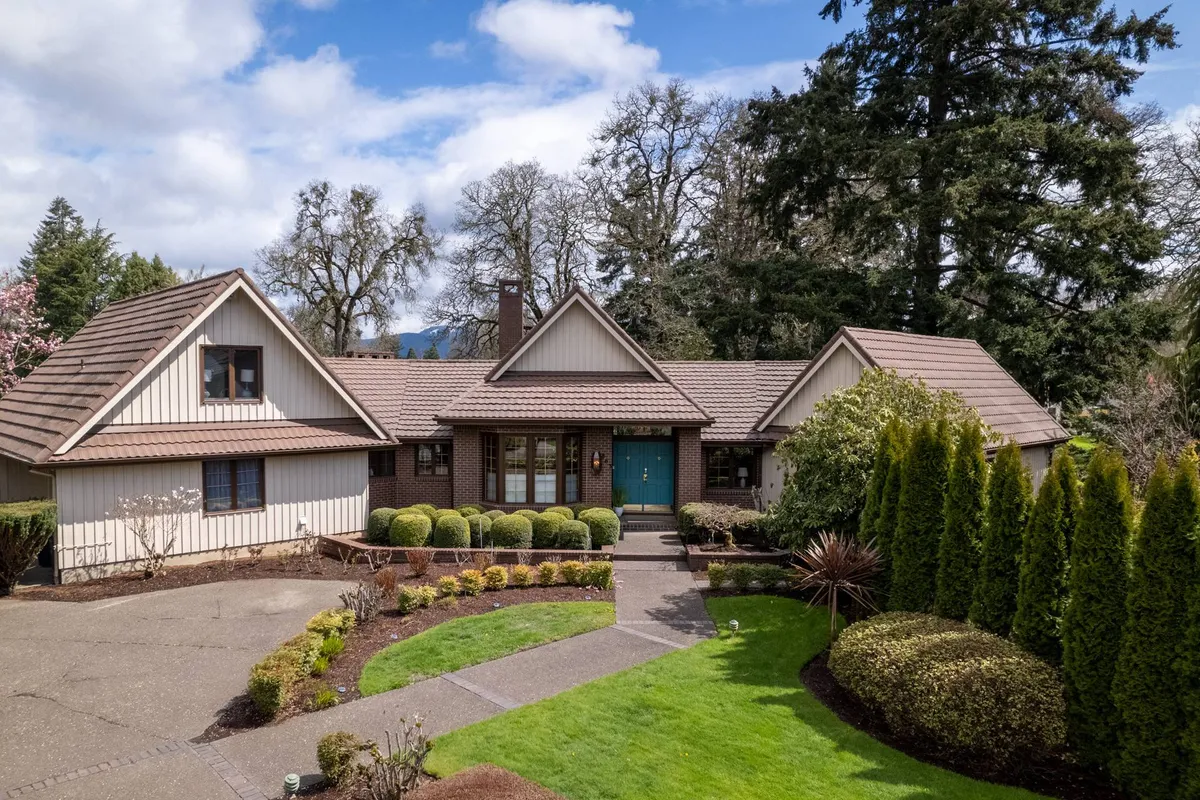 This exterior image showcases the inviting front door of the property, framed by a beautifully landscaped garden and a welcoming pathway. The scene hints at the home's curb appeal and the serene outdoor spaces where families can gather for outdoor barbecues, holiday events, and casual relaxation. The garden and porch offer glimpses of sunset views and seasonal decorations that set a festive, communal mood.